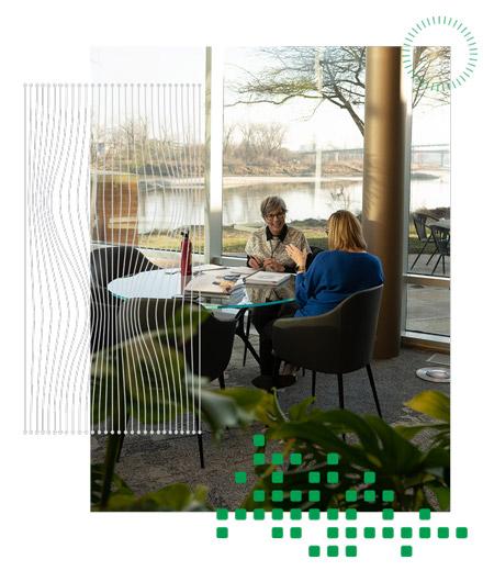 Two women having a meeting at a table in front of a river.